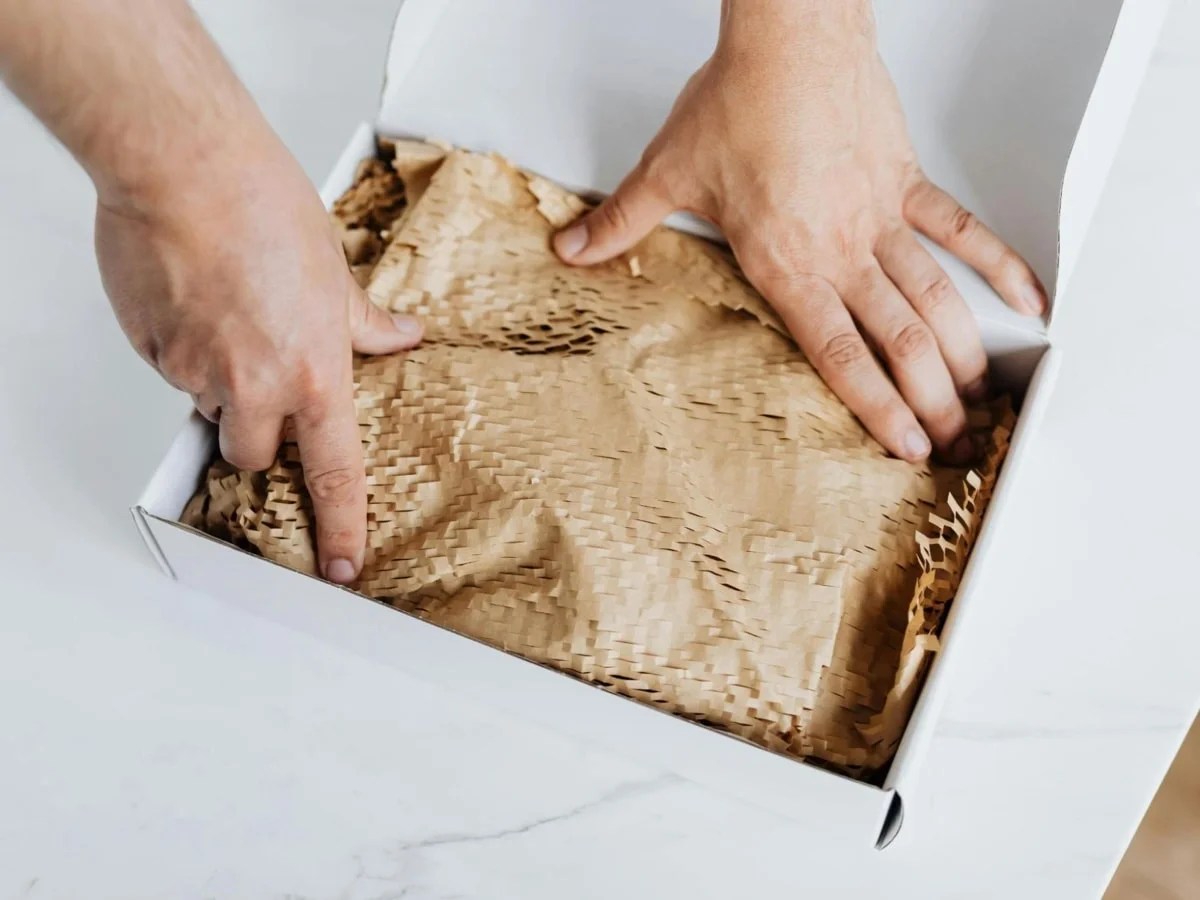 someone packing a box with eco-friendly materials